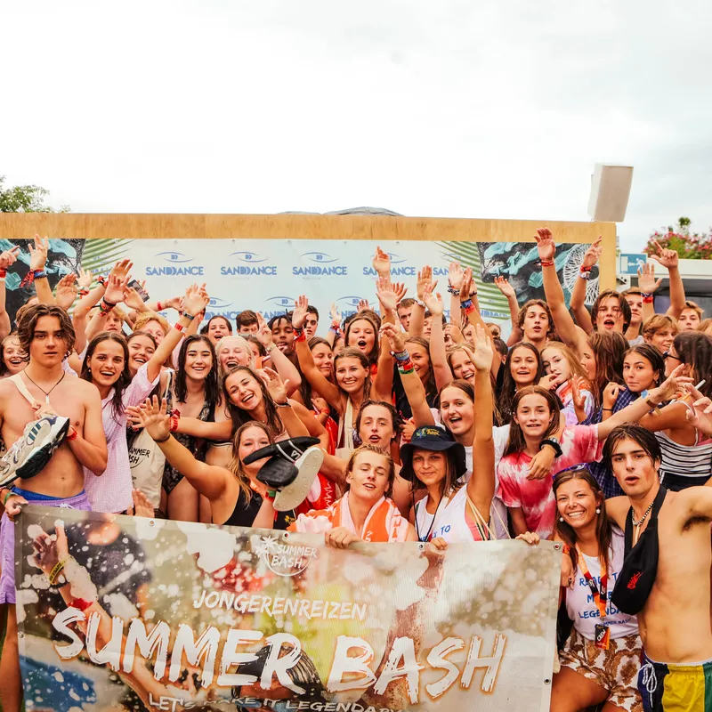Groepsfoto jongeren op poolparty met Summer Bash vlag tijdens begeleide jongerenreis