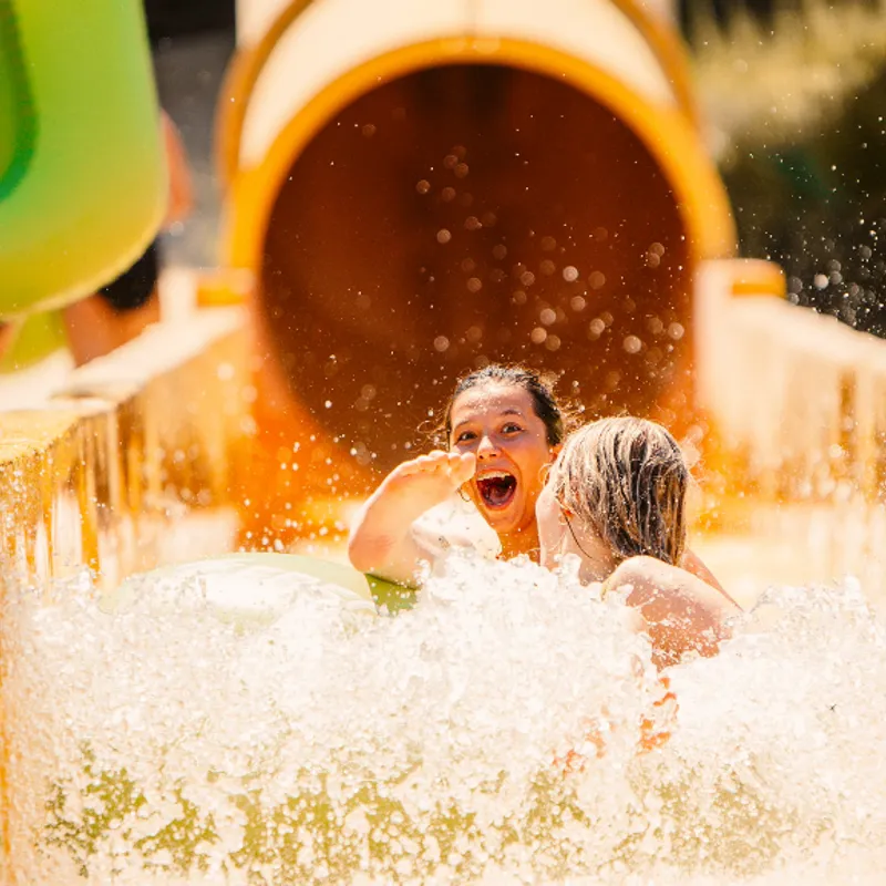 Jongeren gaan van de glijbaan tijdens Summer Bash vakantie